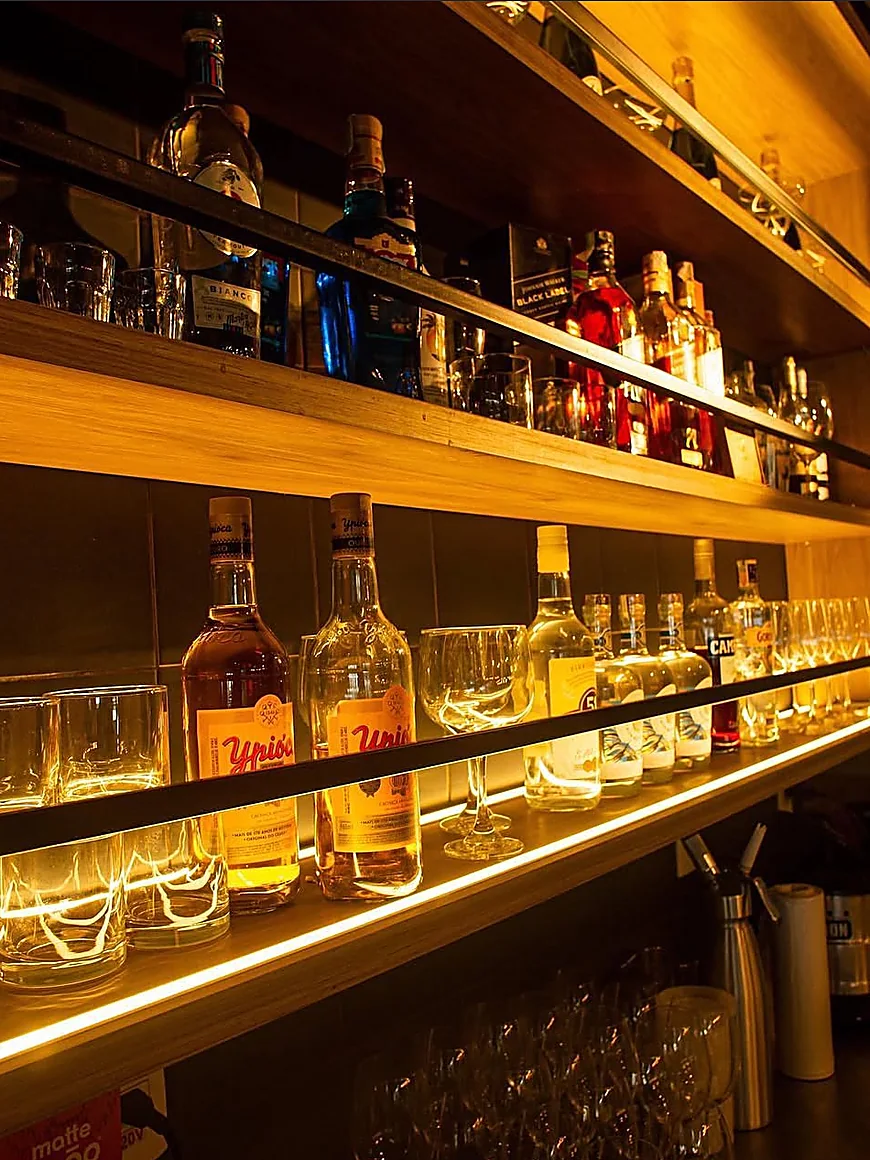 Adega iluminada com prateleiras de bebidas