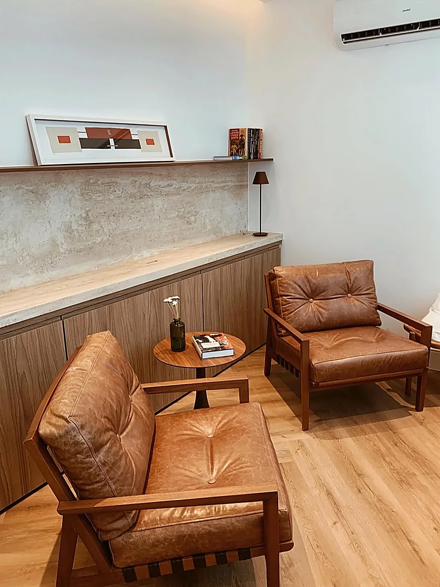 Sala de espera com poltronas de couro e marcenaria